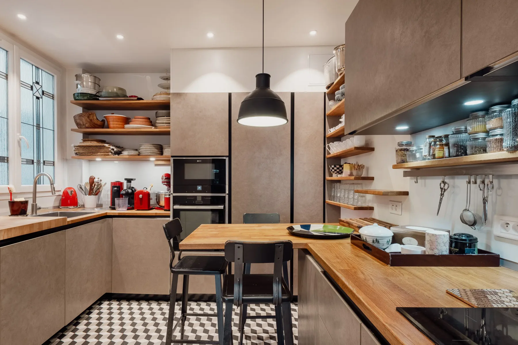 A modern kitchen with wood countertops, open shelving, and a dining table.