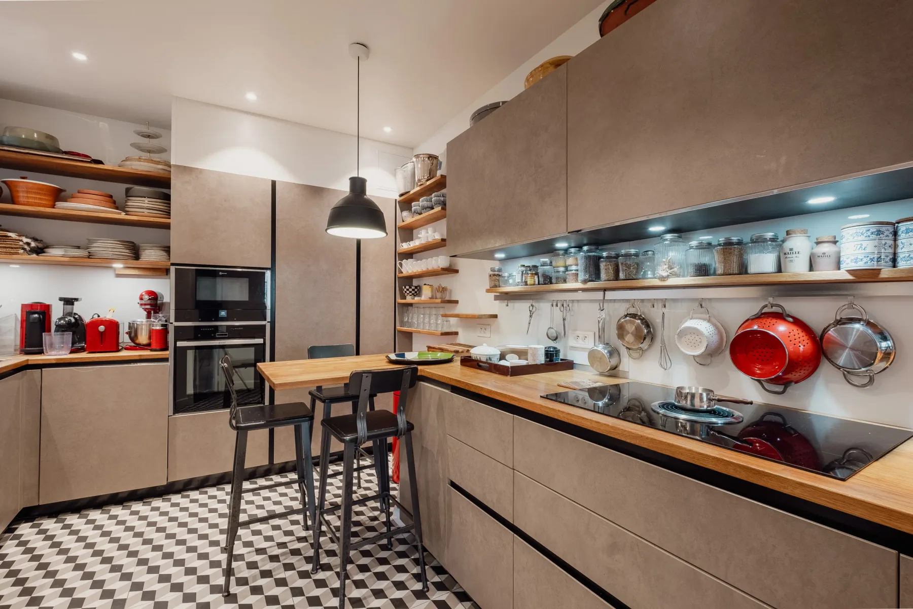 A modern kitchen with a central island and open shelves of dishes.