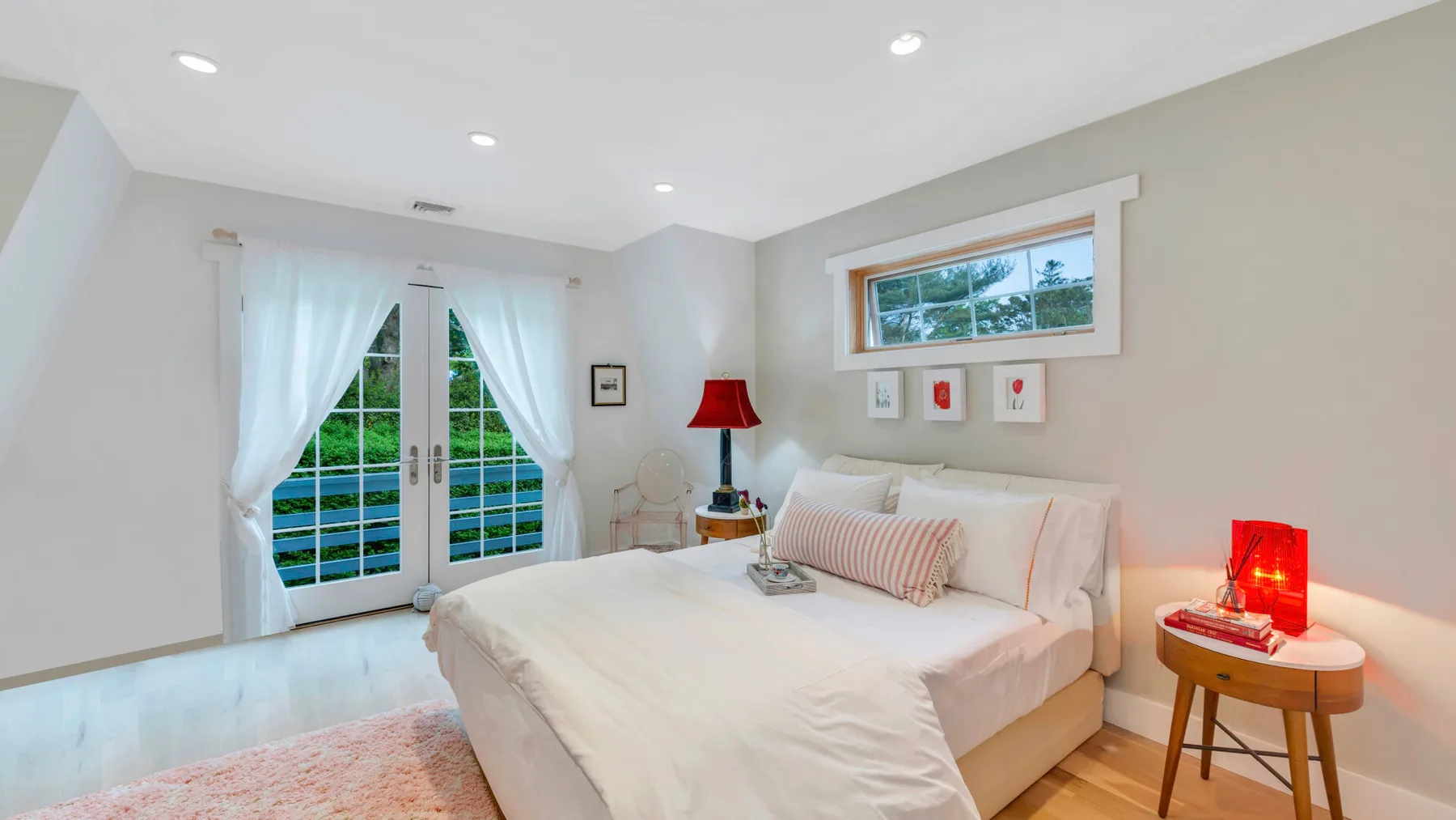 Un dormitorio luminoso con una cama tendida junto a puertas francesas.