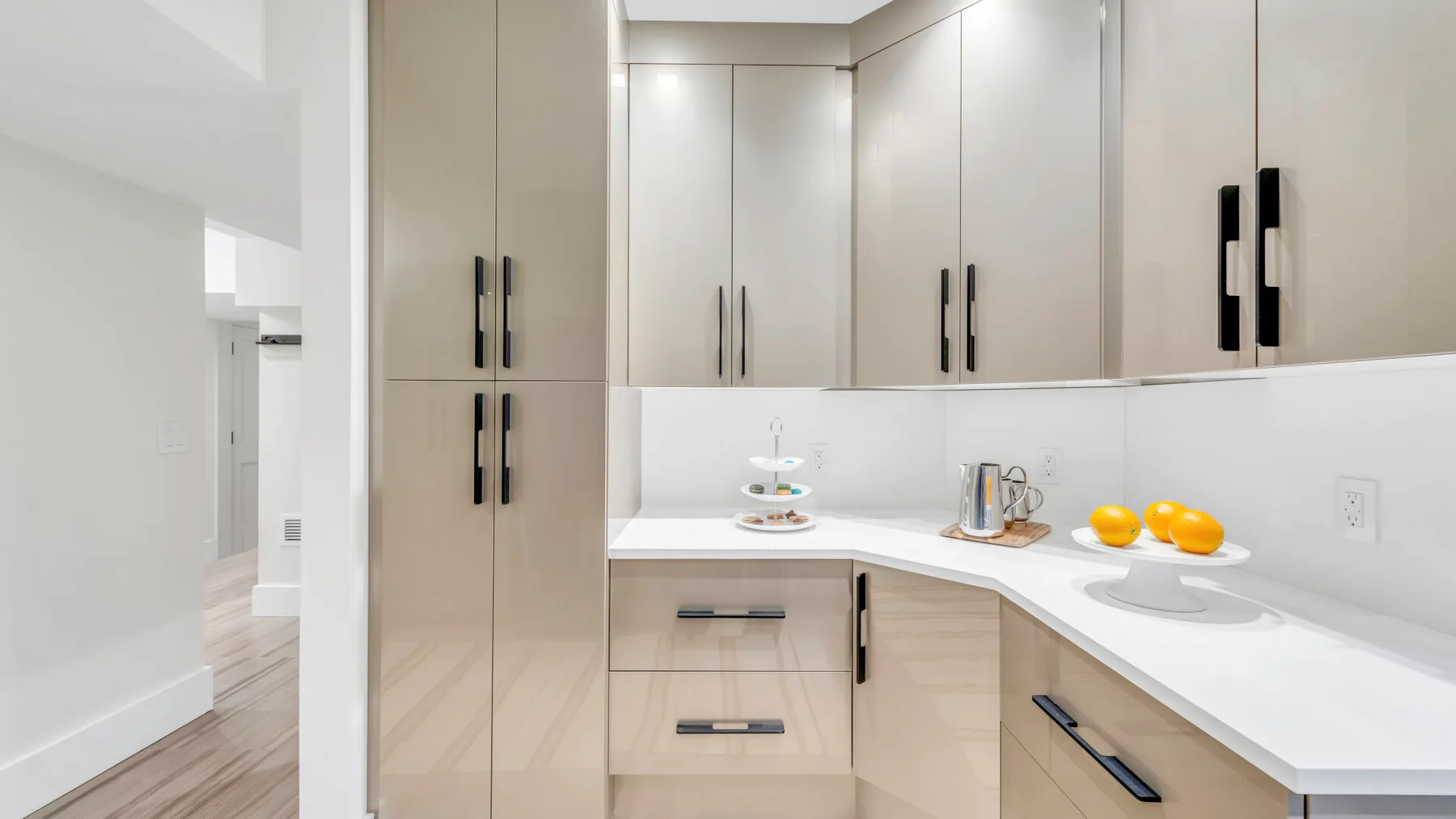 Una cocina moderna con gabinetes claros, una encimera blanca y fruta.