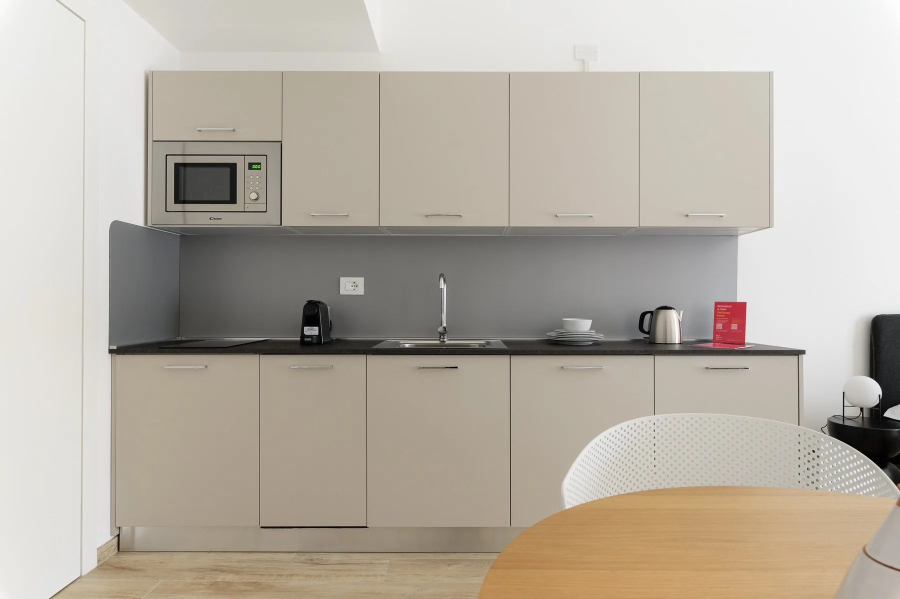 Una cocina moderna con gabinetes beige y una encimera oscura.