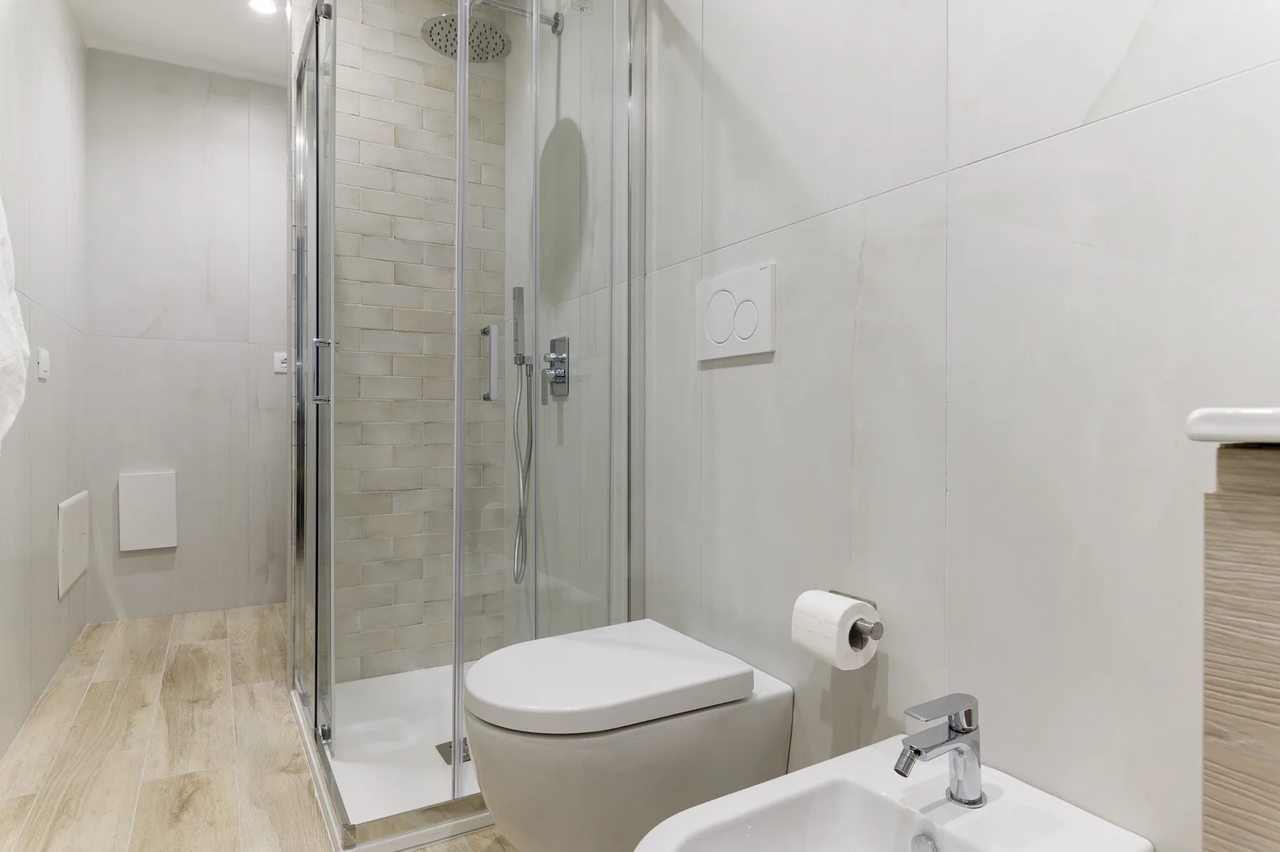 Un baño con ducha de cristal, inodoro y lavabo.