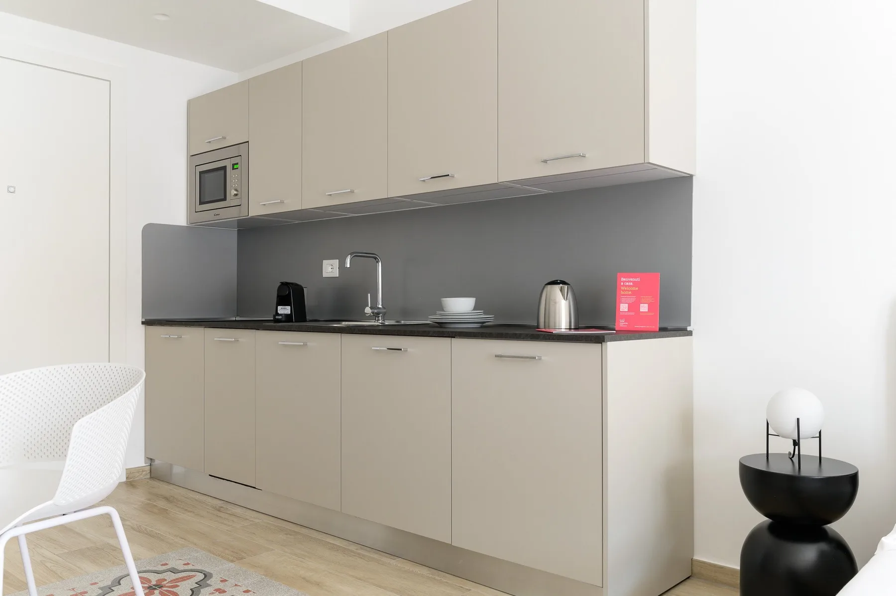 Una cocina moderna con gabinetes claros, salpicadero oscuro y encimera.