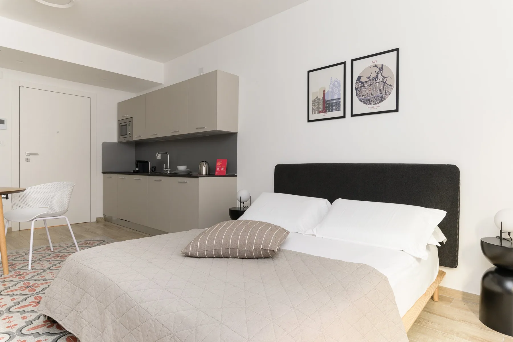 A bedroom with a double bed beside a compact kitchenette.