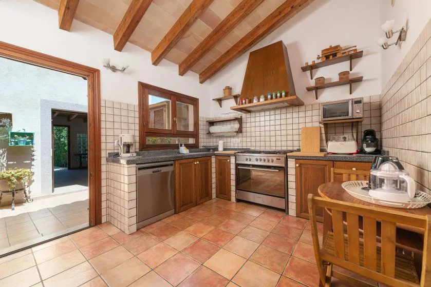 A tiled kitchen with wooden cabinets, a range, and a dining table.