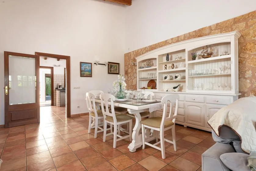 A dining area with a table and chairs beside a large display cabinet.