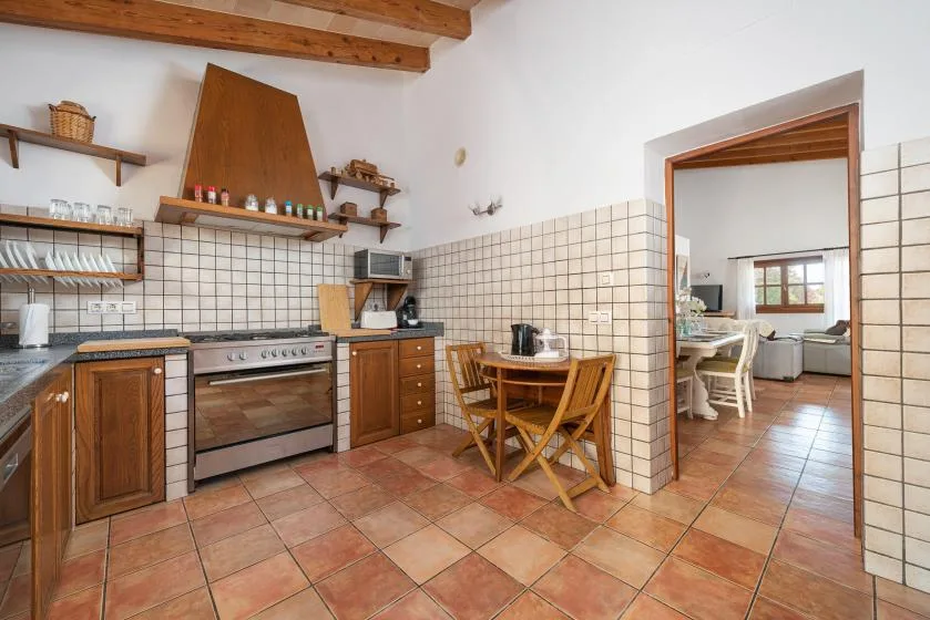 A tiled kitchen with wooden cabinets and a small dining table.