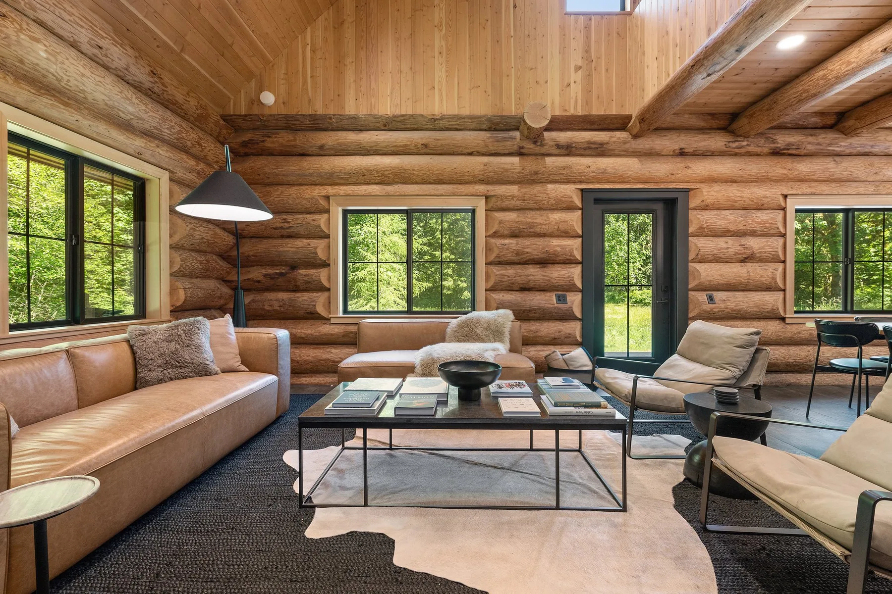 A log-walled living room with seating around a coffee table.