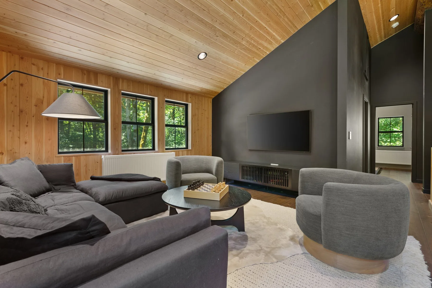 A living room with seating arranged around a coffee table and television.