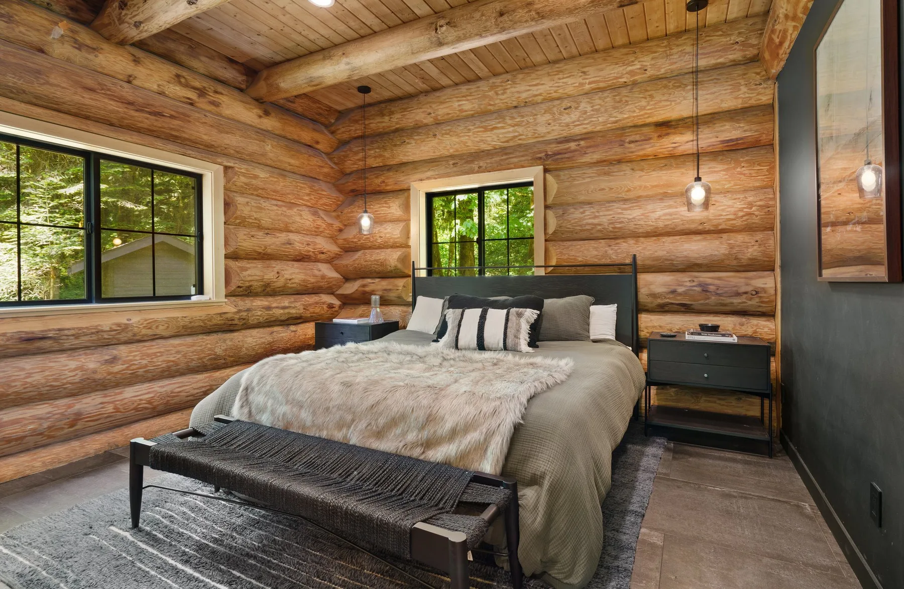A bedroom with a large bed beneath exposed wooden beams.