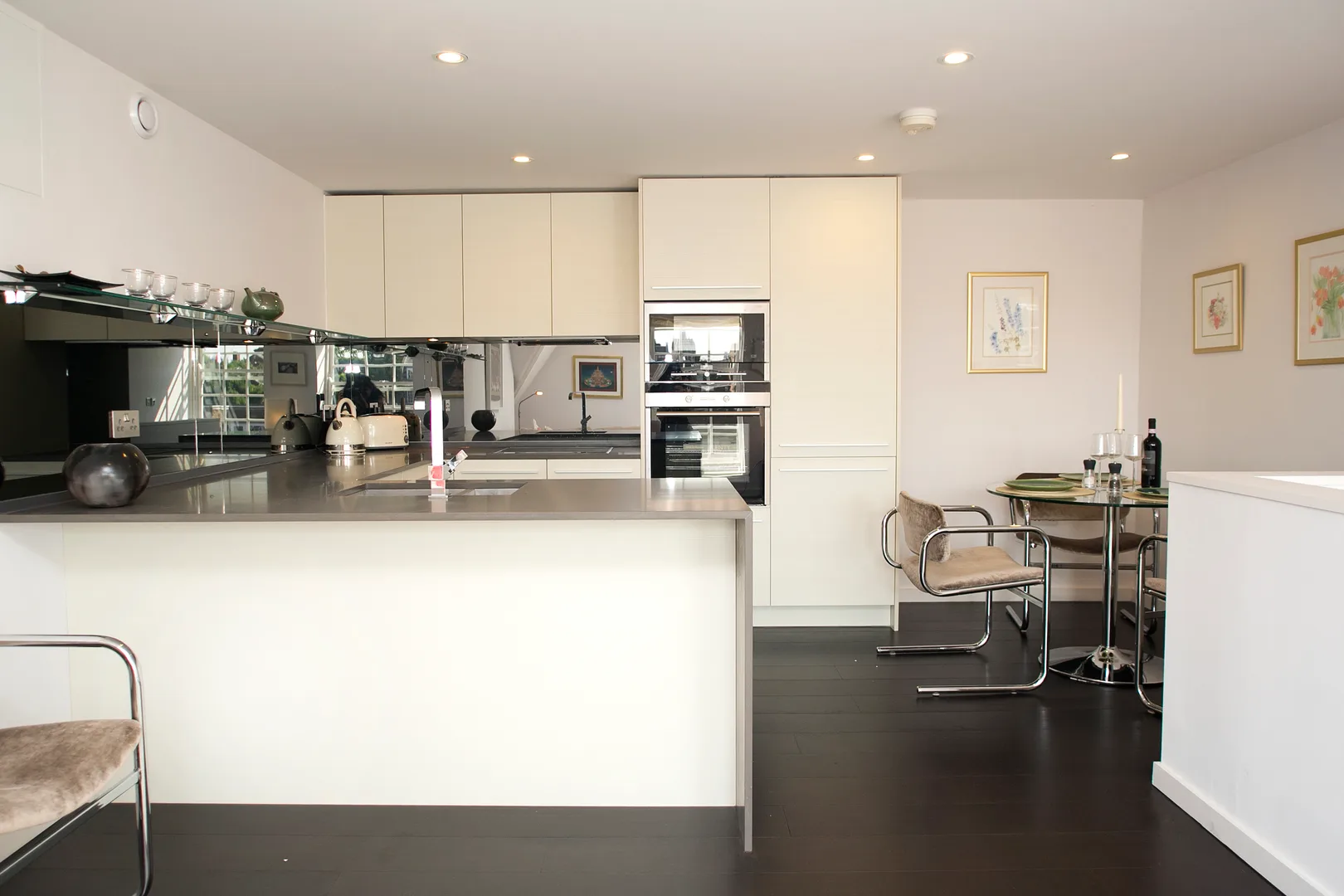 A bright kitchen with a wide island and a small dining table.