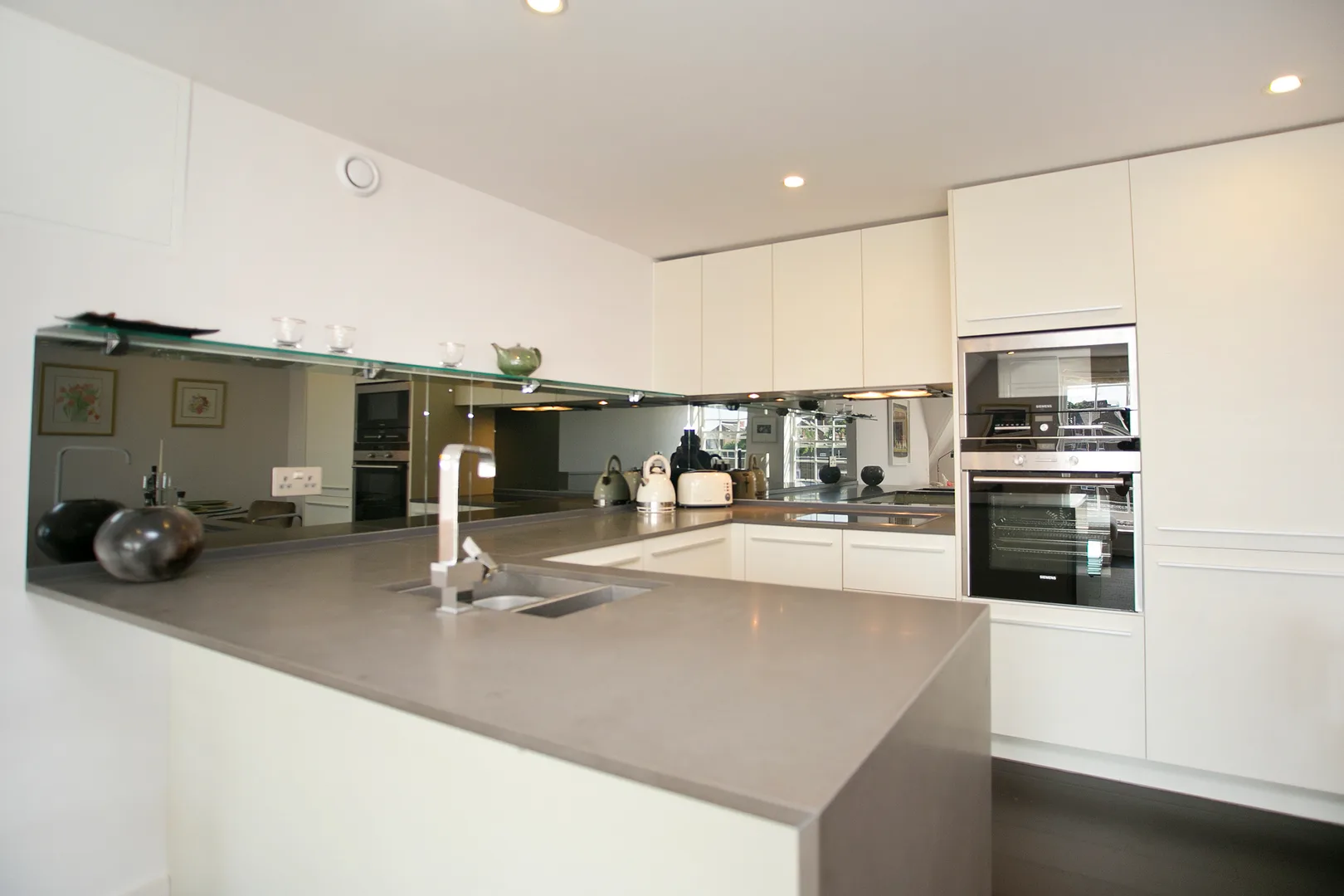 A modern kitchen with a broad island counter and built-in appliances.