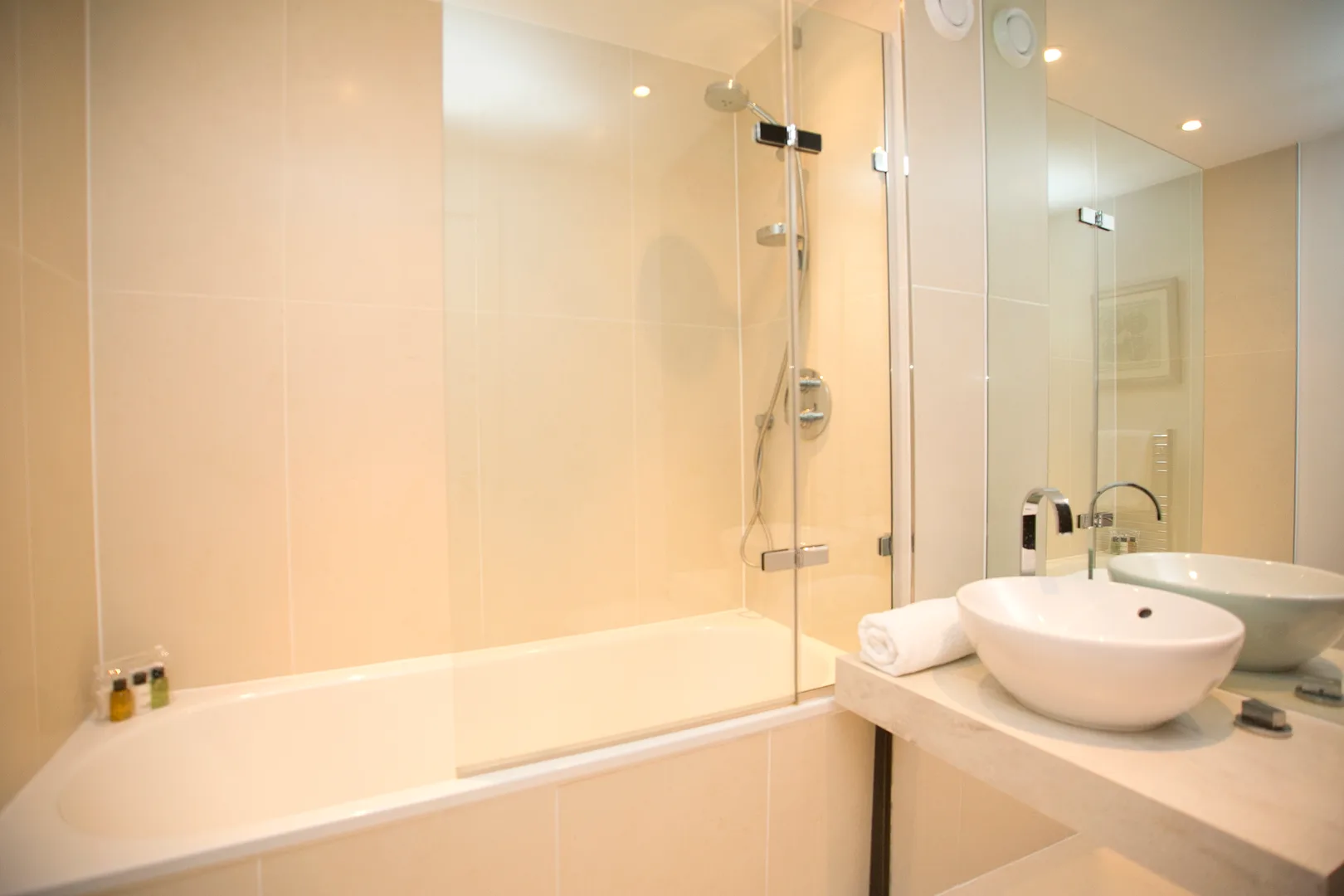 A bathroom with a bathtub, shower, and vessel sink.