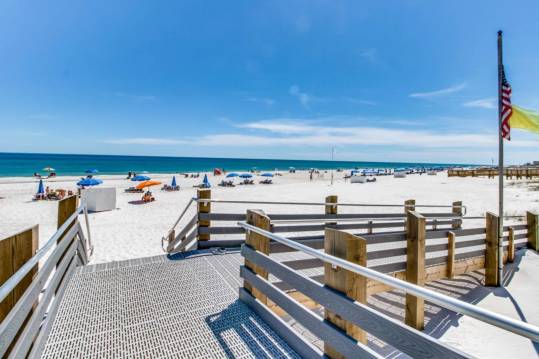 A beach access ramp overlooks a sandy beach and the ocean.