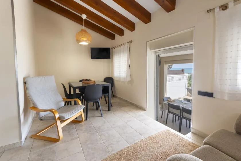 A dining area with a table and chairs beside a lounge chair.