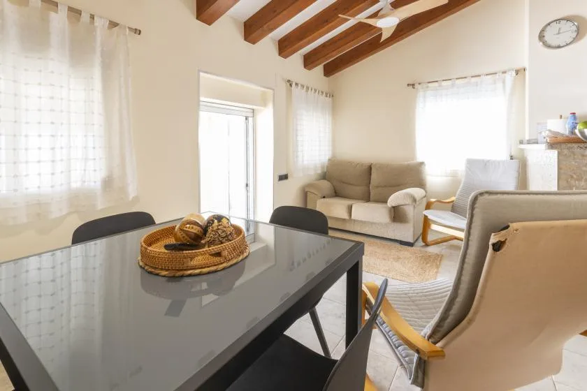 Una luminosa sala de estar y comedor con una mesa de cristal y asientos.