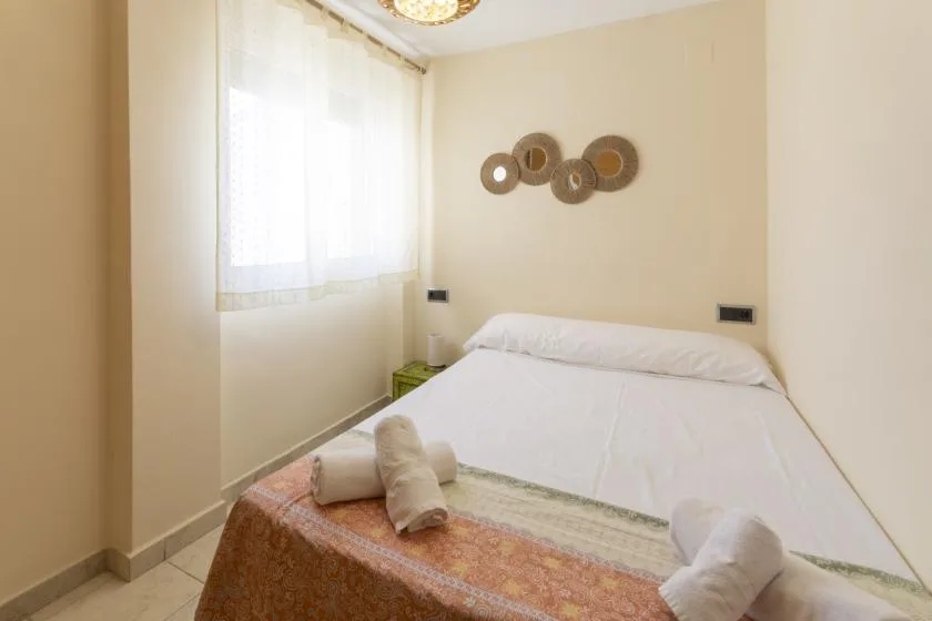 Un dormitorio con una cama blanca bajo adornos circulares en la pared.