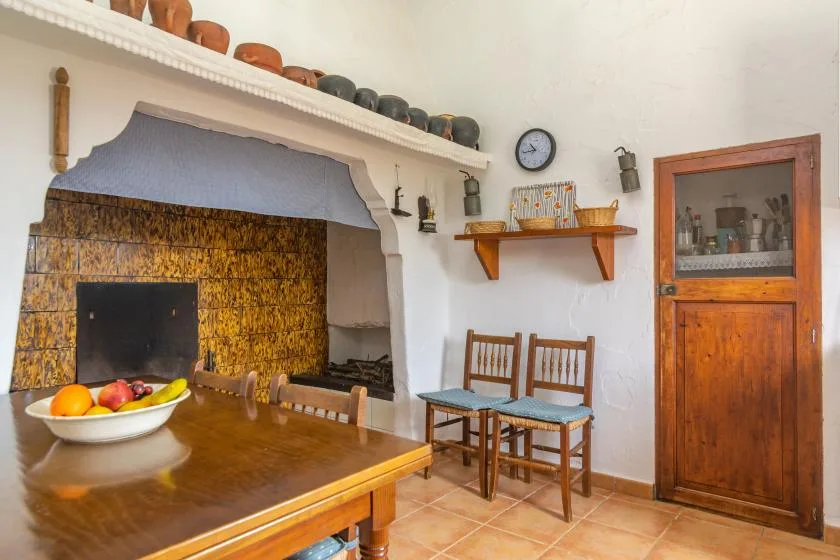 Un comedor rústico con una mesa de madera junto a una chimenea de piedra.