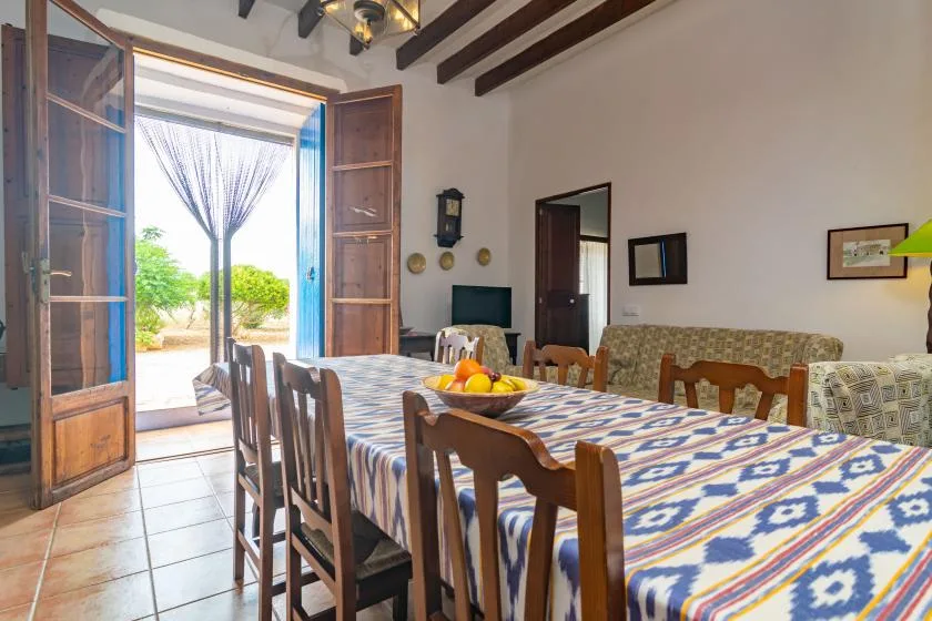 Comedor con una mesa larga cubierta con un mantel estampado.