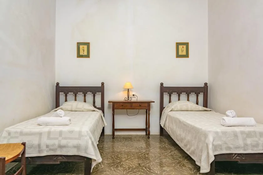 Un dormitorio con dos camas individuales y una mesita entre ellas.