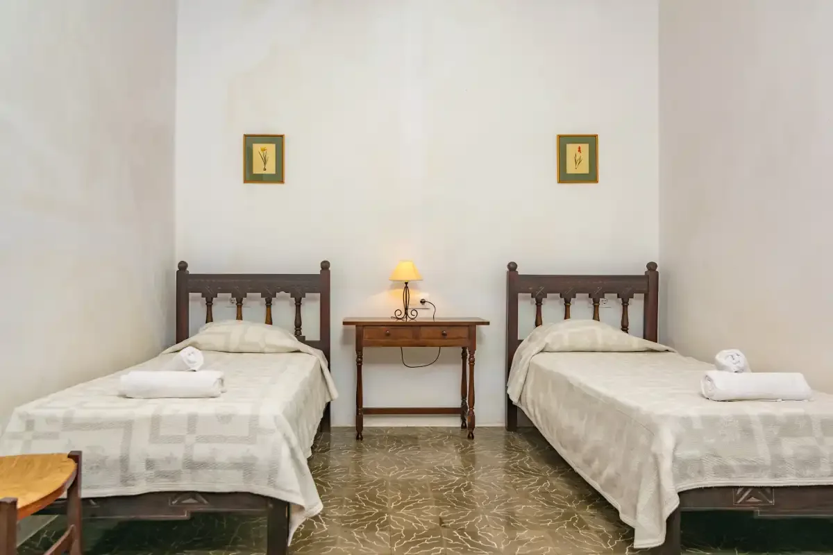 Un dormitorio con dos camas y una mesita entre ellas.