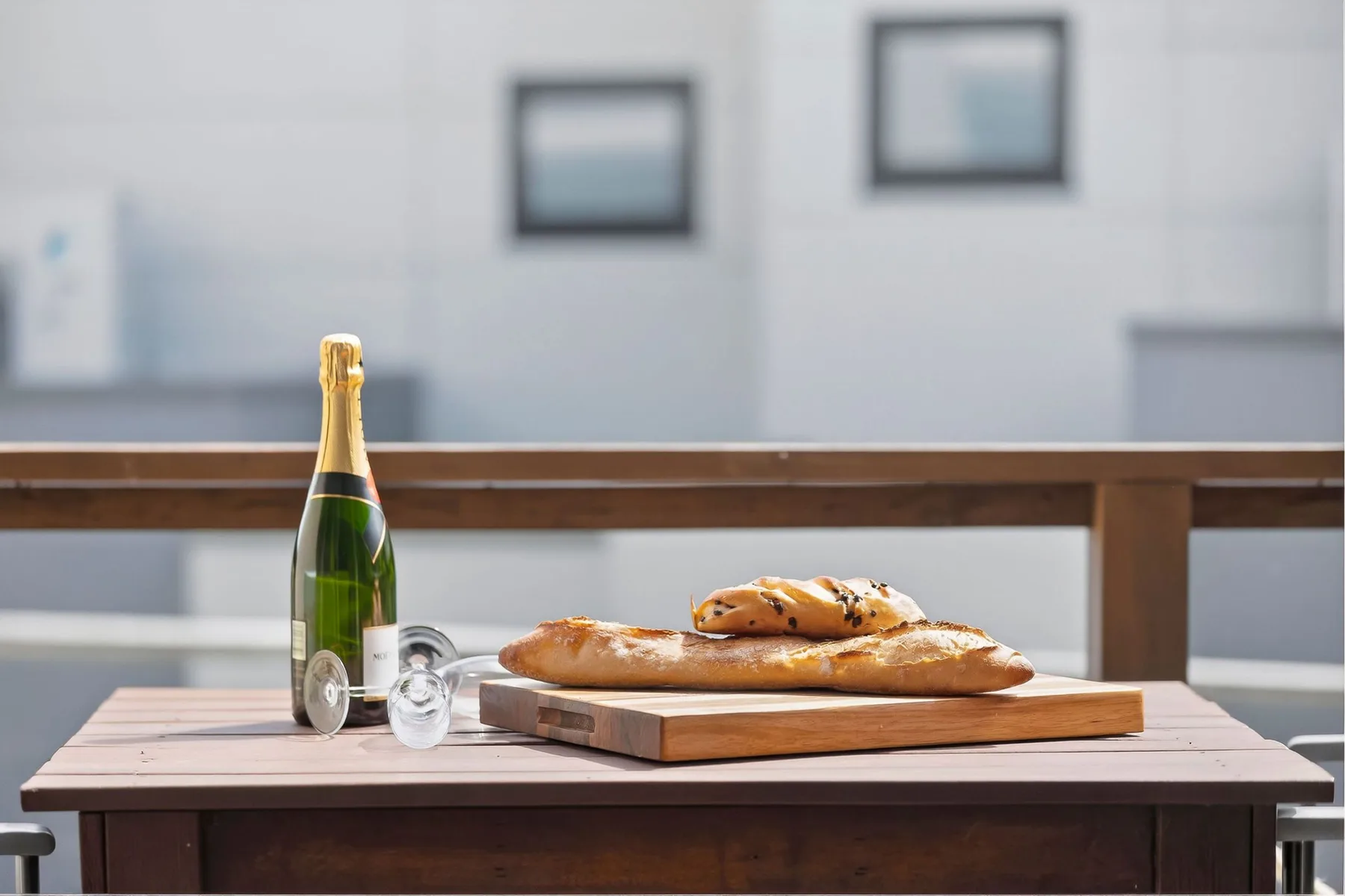 A baguette, pastries, and a bottle sit on a table.
