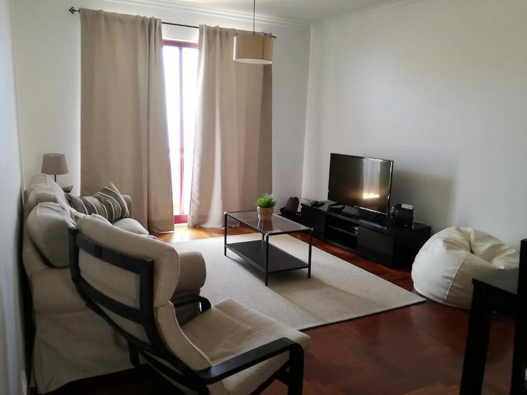 Una sala de estar con asientos alrededor de una mesa de centro y un televisor.