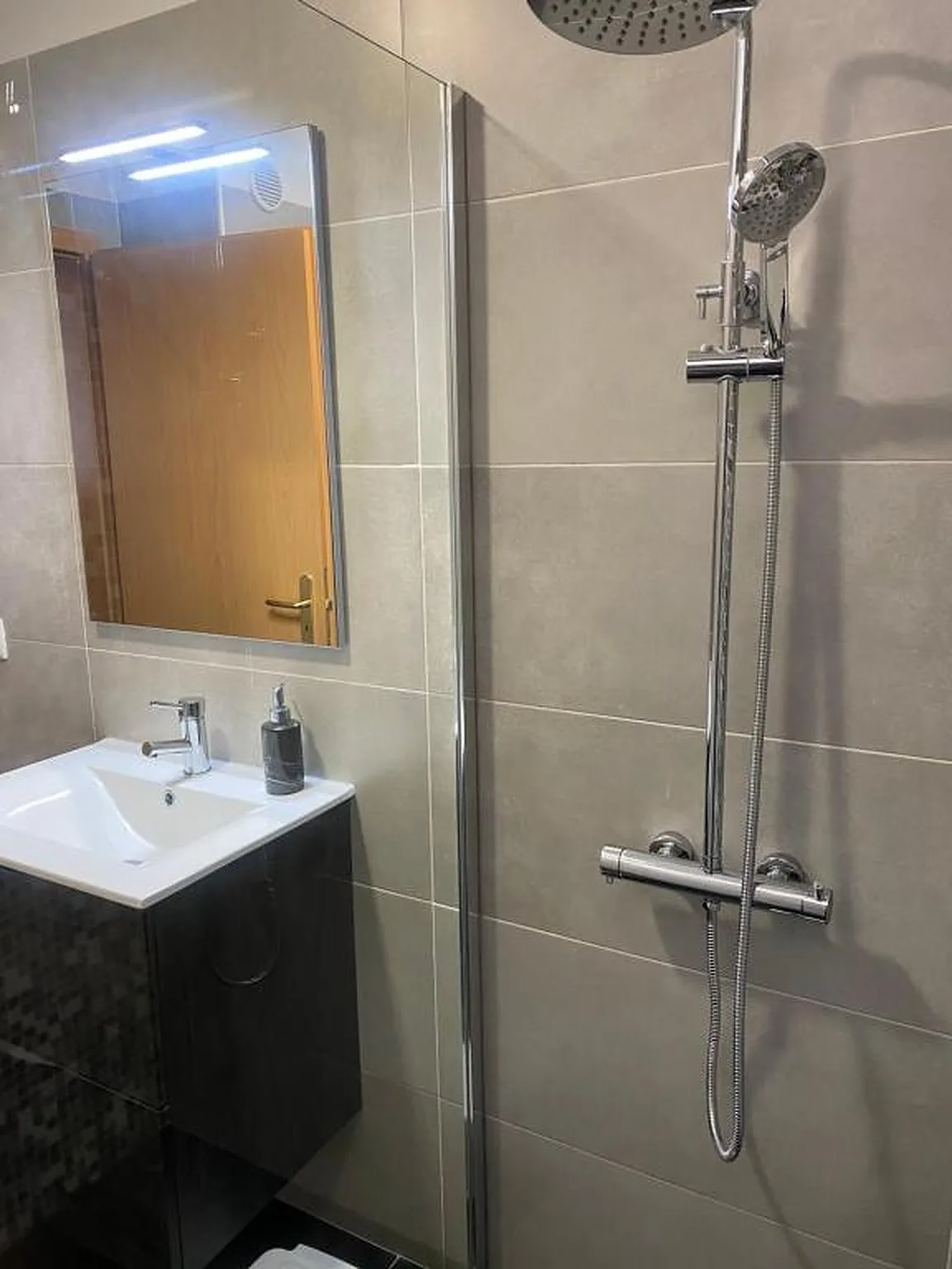 Un baño alicatado con lavabo y ducha.