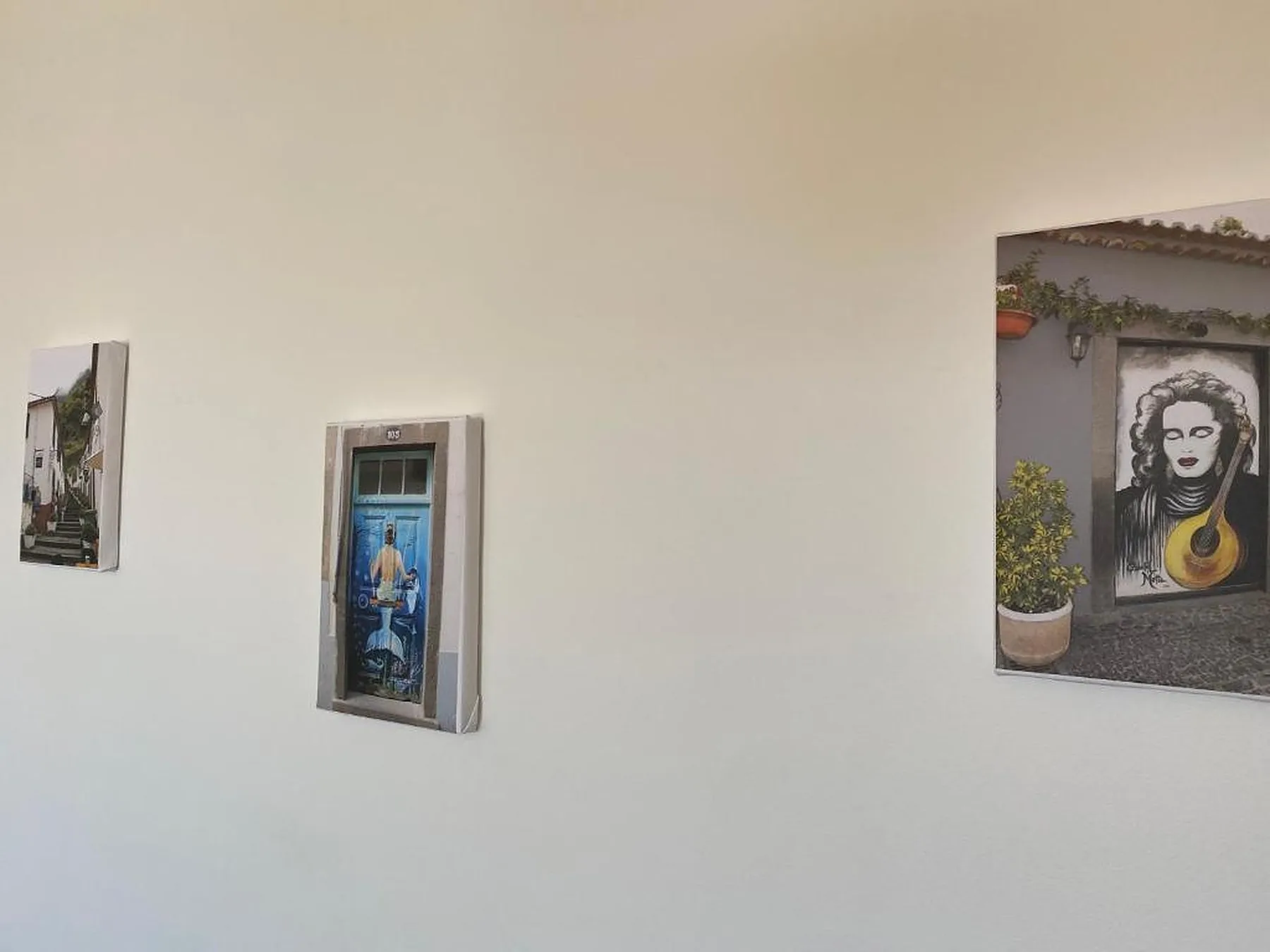 Una pared interior muestra tres obras de arte enmarcadas.
