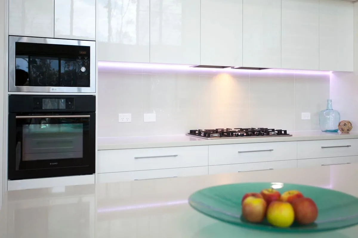 Una cocina moderna y luminosa con gabinetes blancos y una estufa.