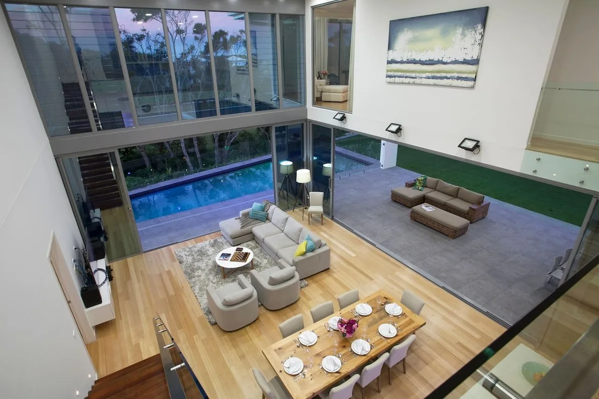 Una luminosa sala de estar y comedor se abre a un patio junto a una piscina.