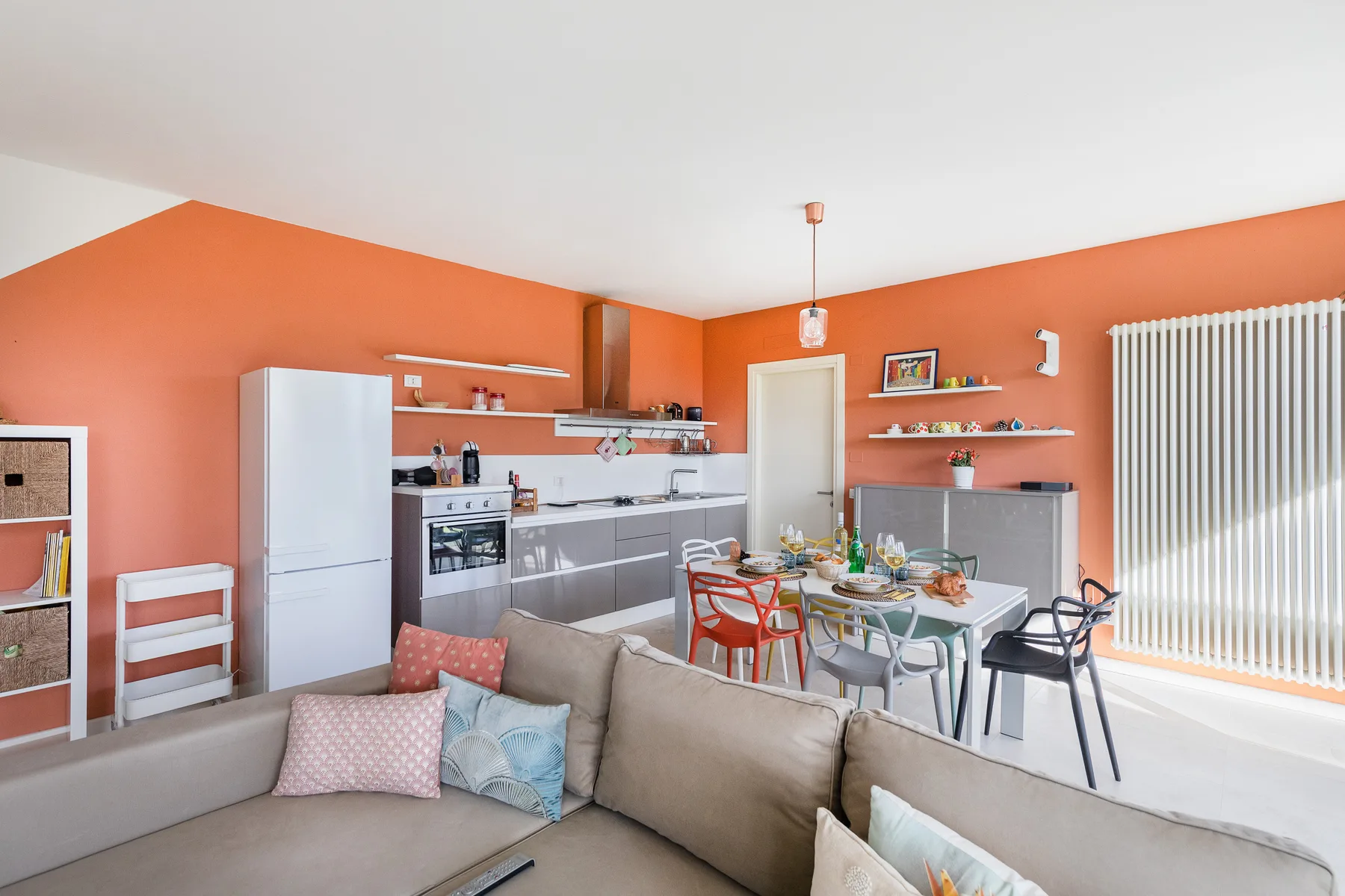 A bright open-plan living and kitchen area with a dining table and seating.