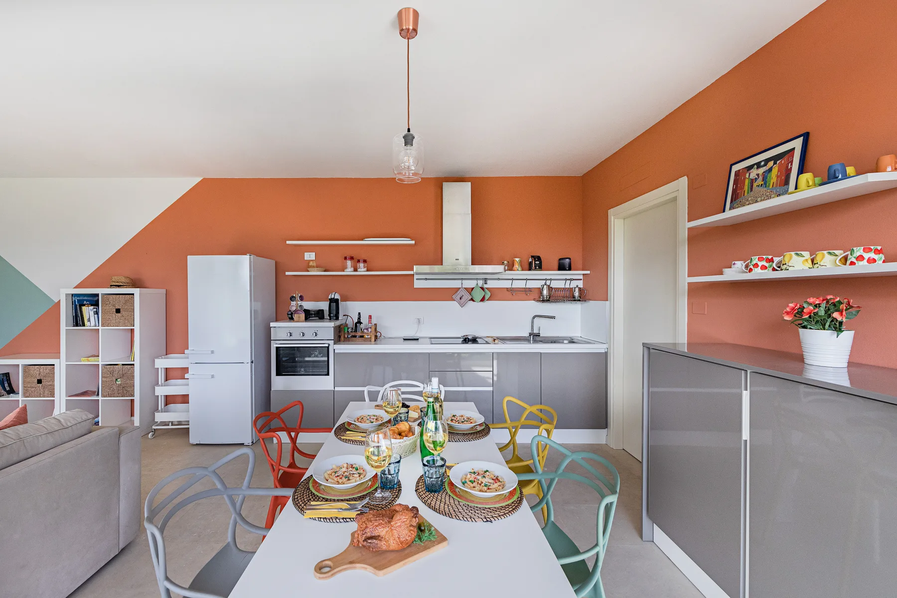 A dining table set with dishes sits in an open kitchen and living area.