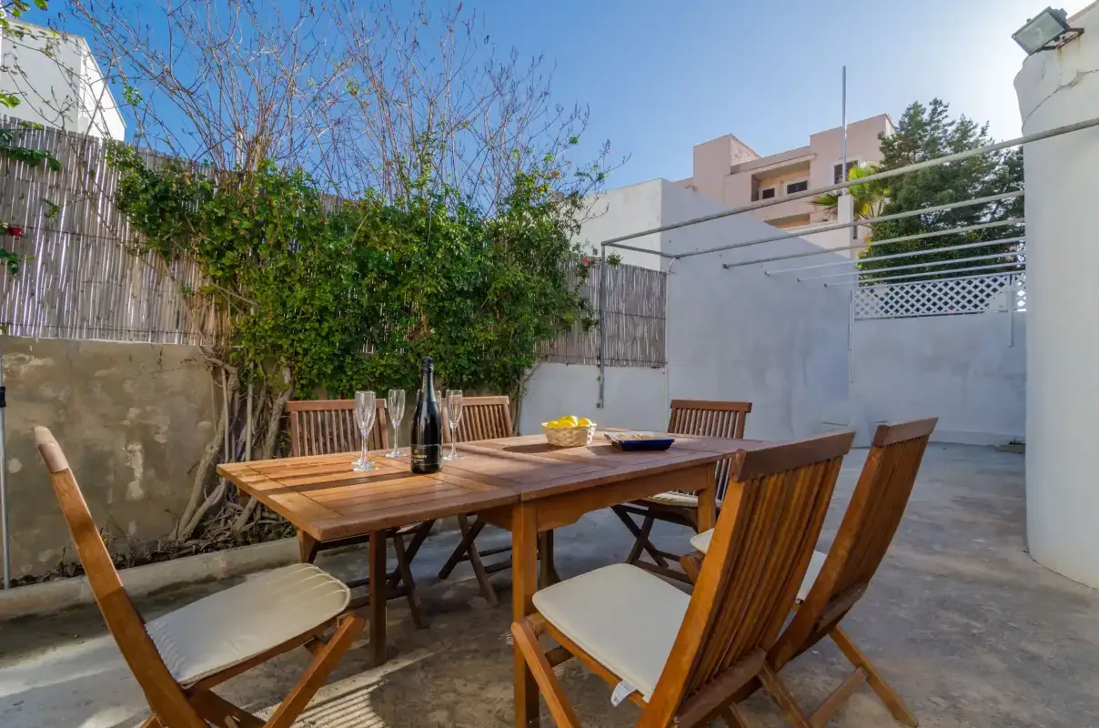 Una zona de comedor exterior con una mesa de madera y asientos.