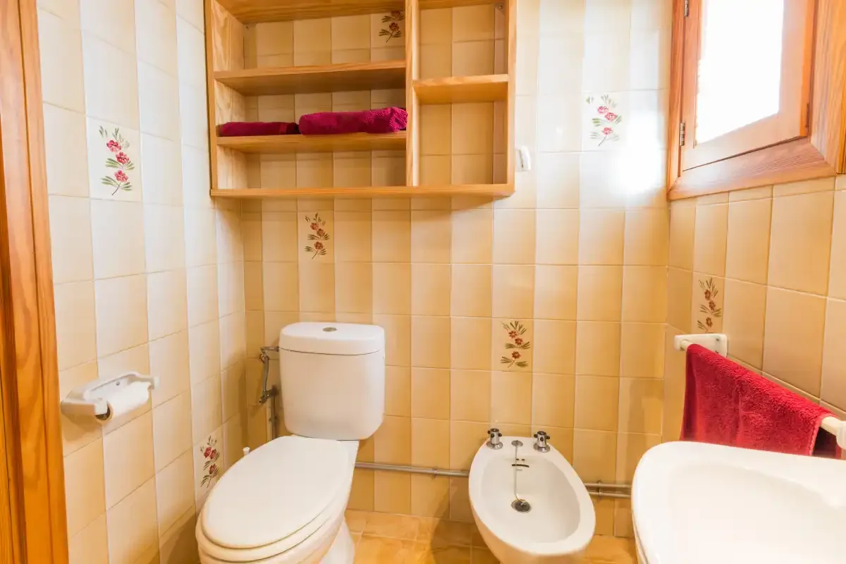 Un baño alicatado con inodoro, bidé y lavabo.