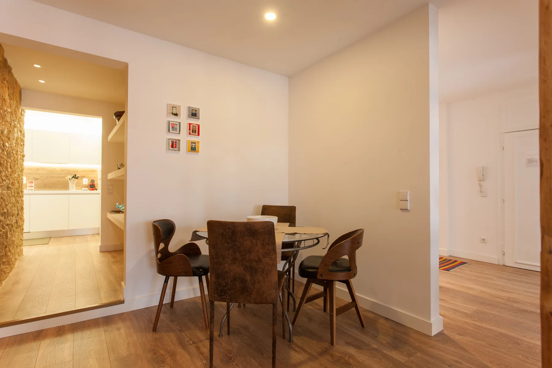 Dining area with a table and chairs beside an open kitchen.