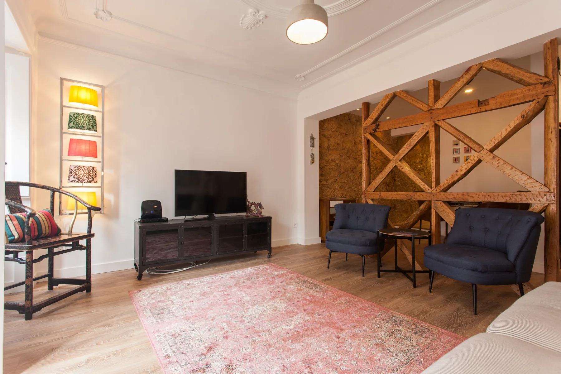 A living room with seating, a television, and a patterned rug.