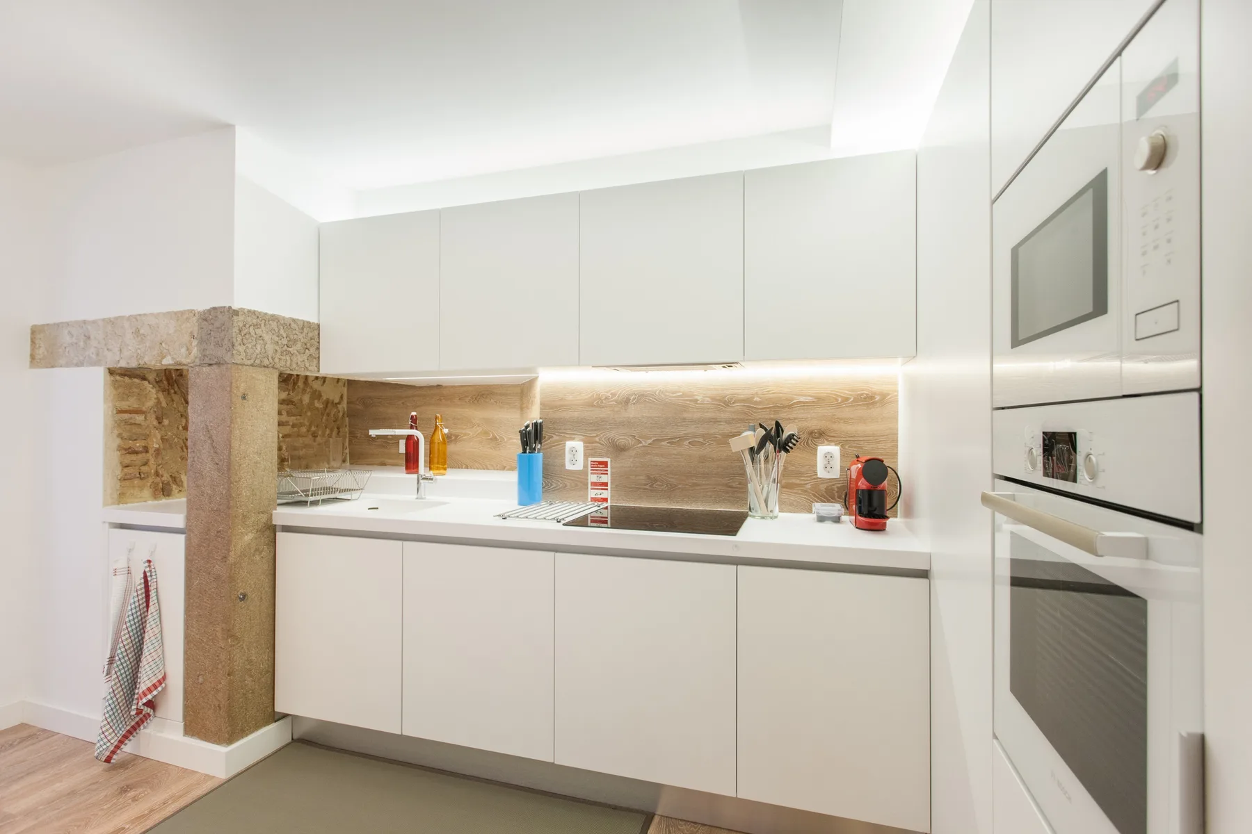 A modern kitchen with white cabinets and a countertop.