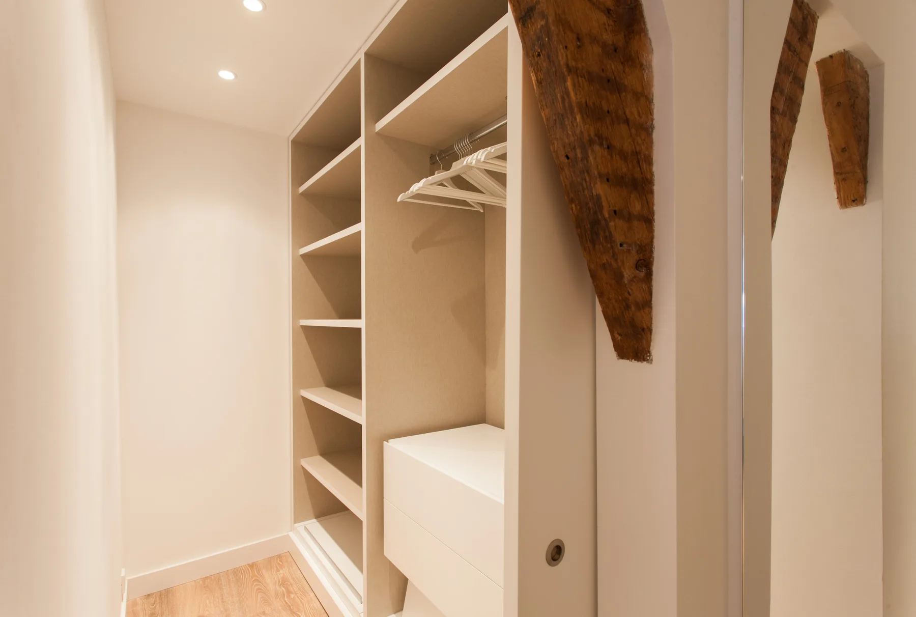 A bright walk-in closet with open shelving and hanging space.
