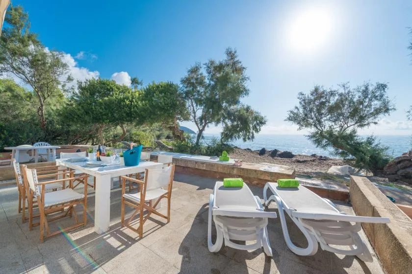 An outdoor dining and lounge area overlooks the sea.