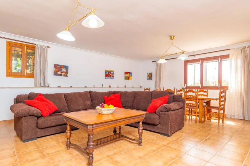 A living and dining area with brown seating, a wooden coffee table, and a dining table.