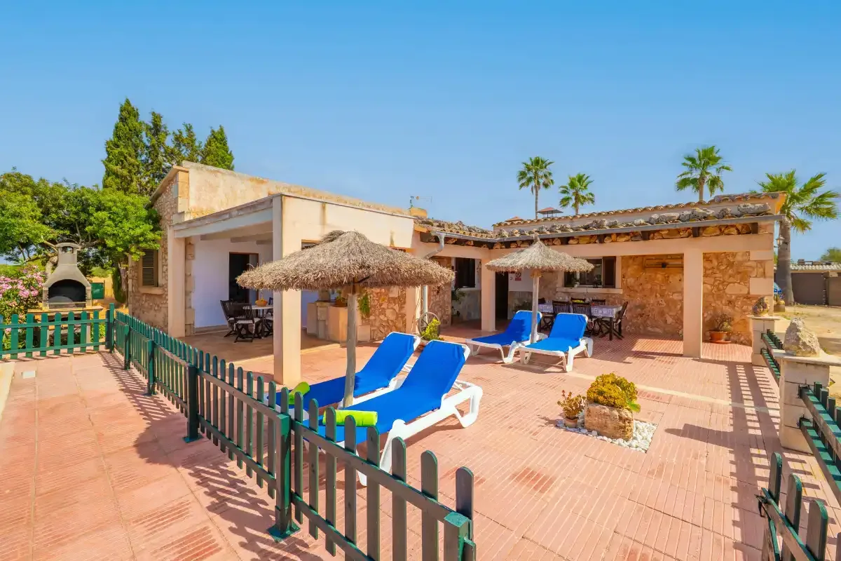 A sunny patio features blue lounge seating and a shaded outdoor dining area.