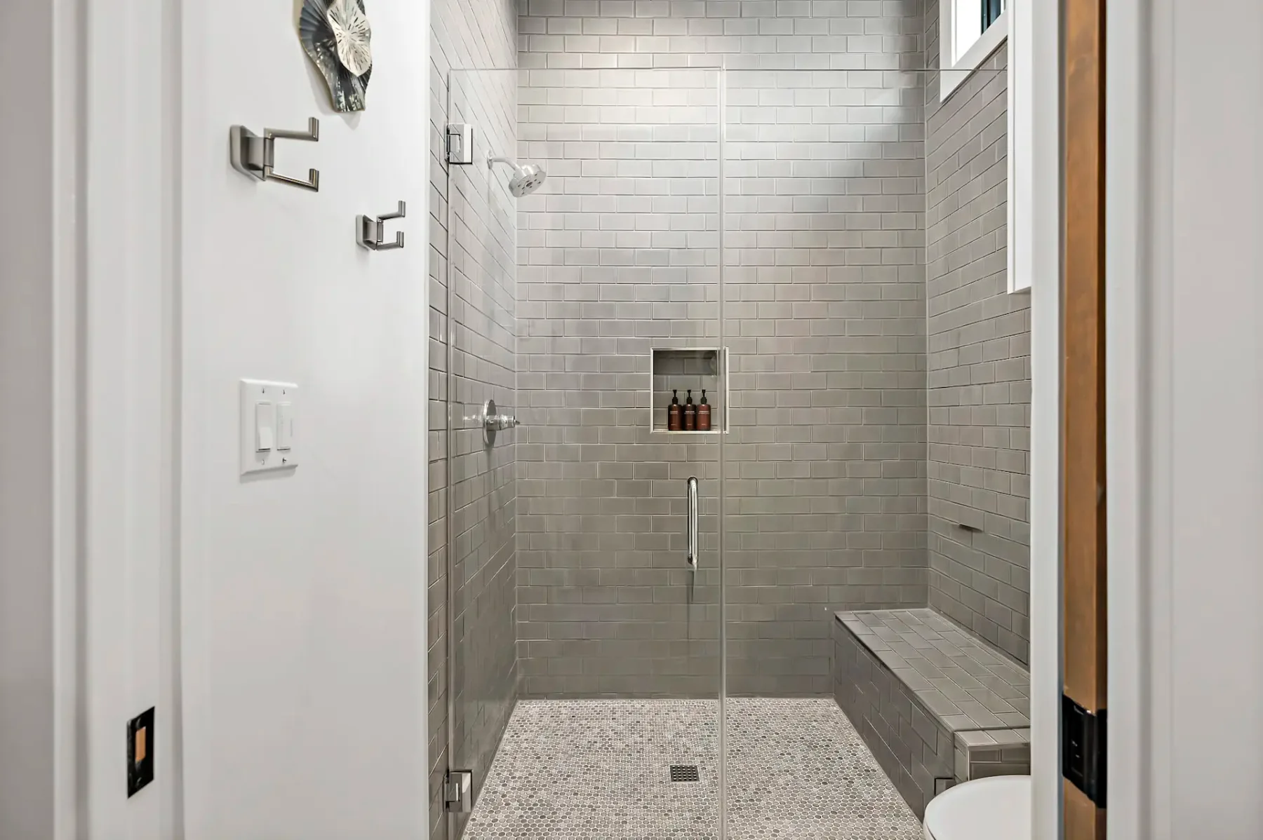 A tiled shower with a built-in niche and a bench.