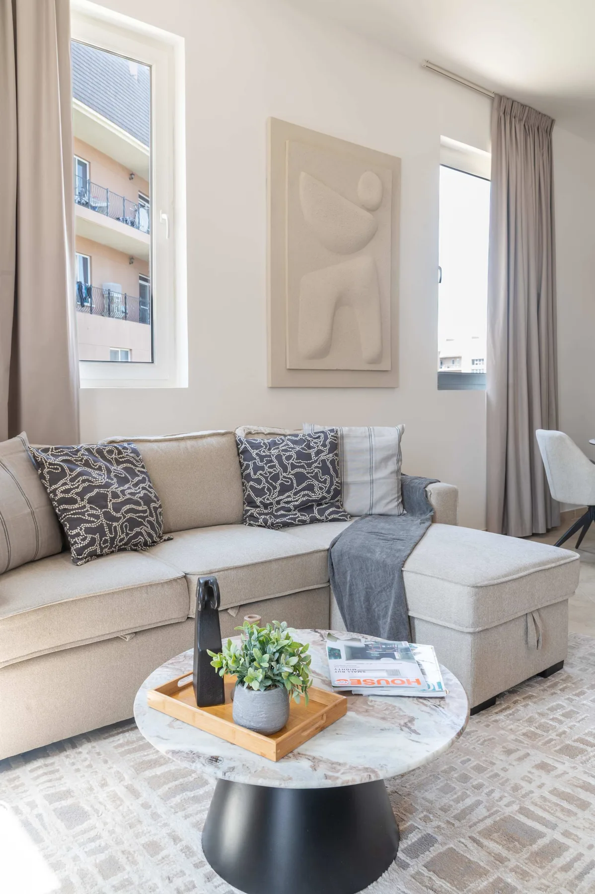 A bright living room with a sectional seating area and a round coffee table.