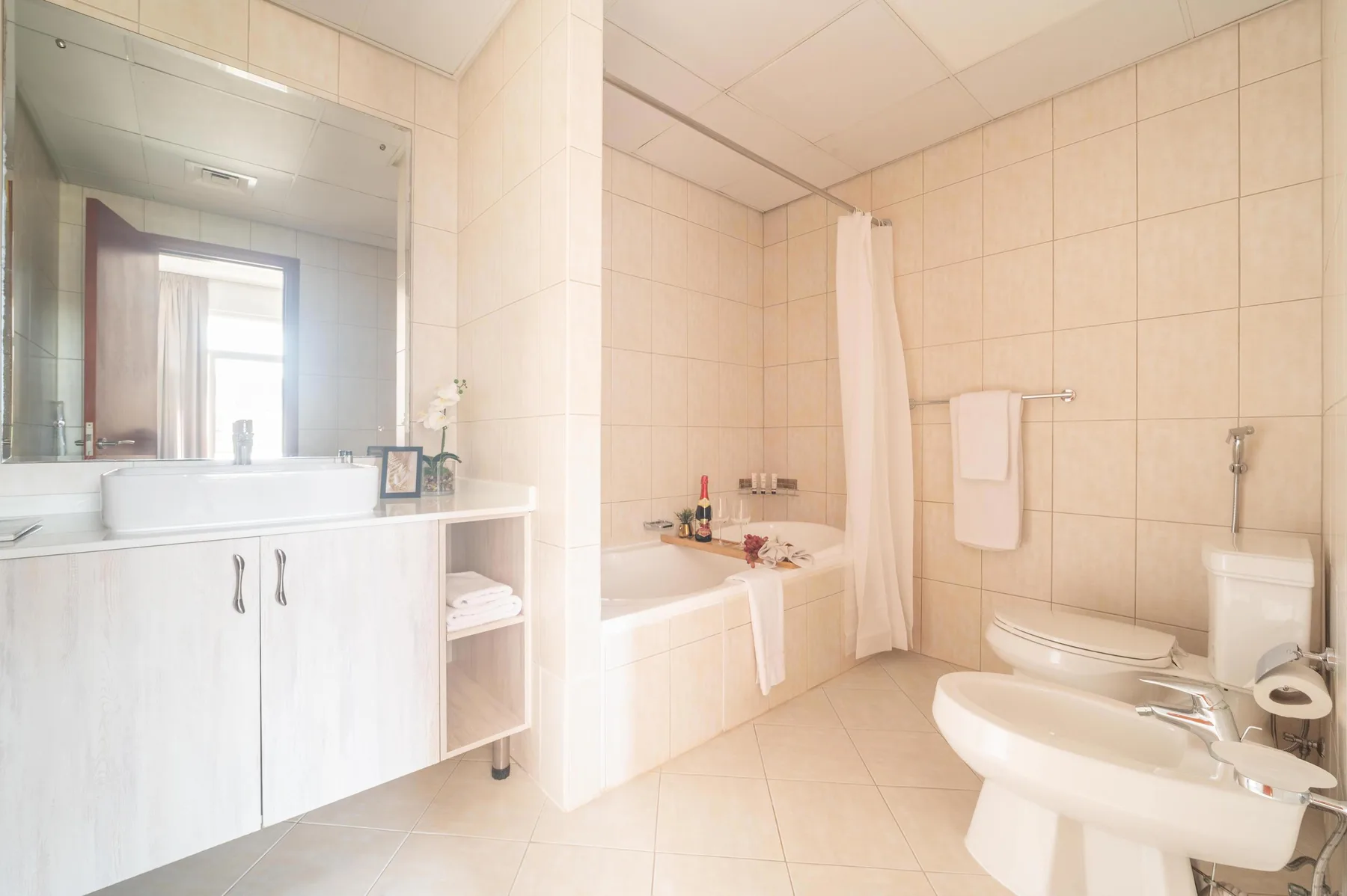 Un baño alicatado con bañera, lavabo e inodoro.