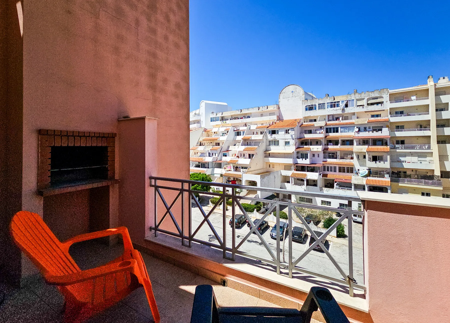 A balcony seating area overlooks nearby apartment buildings.