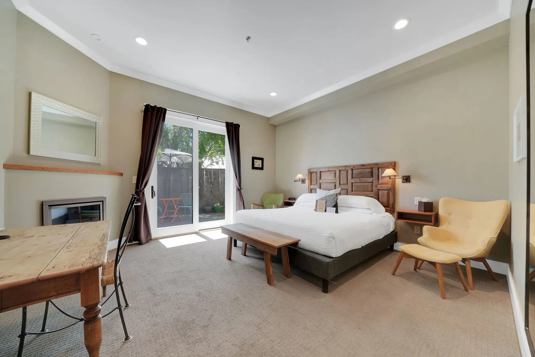 Habitación deluxe con una cama king y puerta corrediza de vidrio que da a un patio.