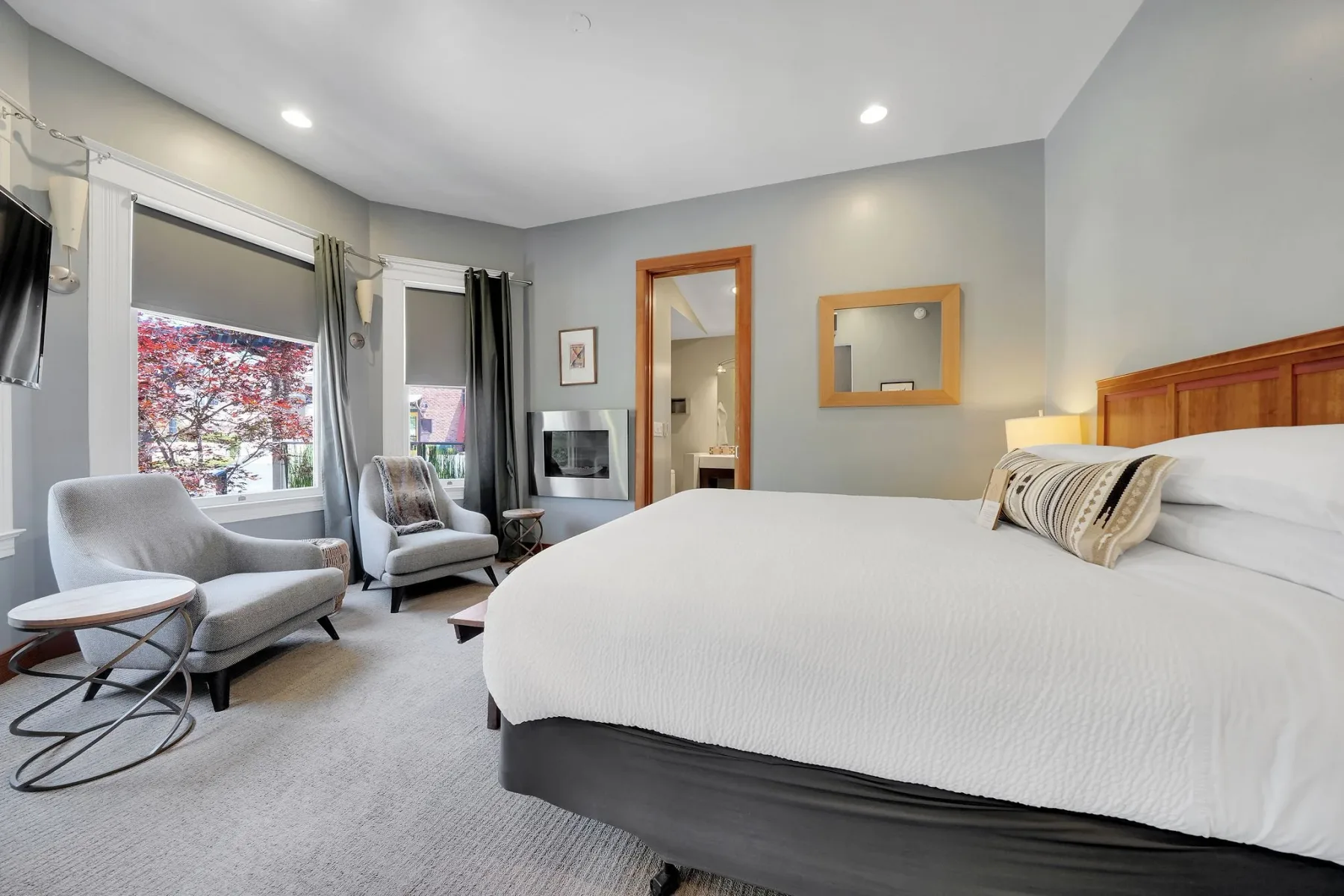 Habitación de casa de campo con una cama, zona de estar y chimenea montada en la pared.