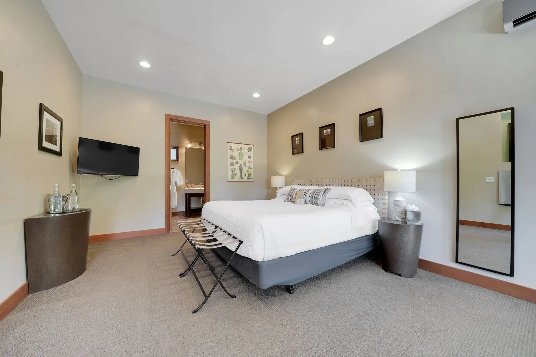 Habitación de casa de campo con una cama y un baño visible a través de una puerta abierta.