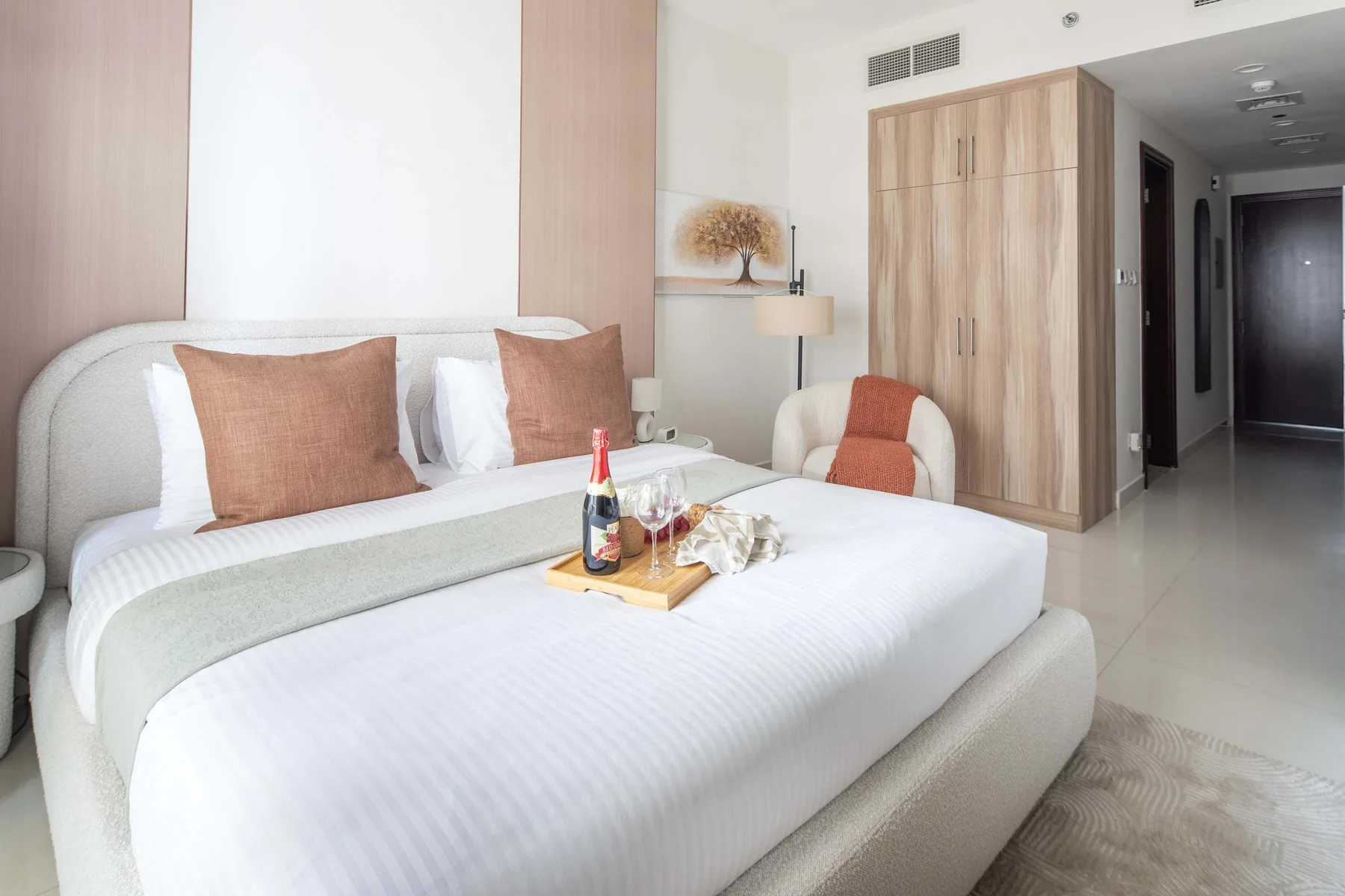 Un dormitorio con una cama bien hecha y un armario.